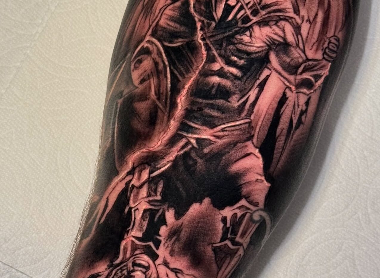 Black and grey reaper and skeleton sleeve tattoo on the forearm